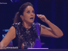 a woman with a surprised look on her face is sitting in front of a microphone with the words devoces above her