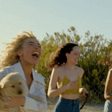 a woman laughs while holding a dog in her arms