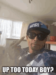 a man wearing sunglasses and a hat with the words up too today boy