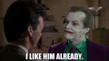 a man in a suit and tie is talking to the joker who says i like him already .