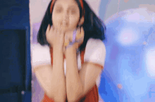 a blurry picture of a woman covering her mouth with her hands