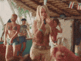 a woman in a bikini singing into a microphone in front of a crowd