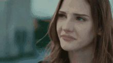 a close up of a woman 's face with a sad look on her face