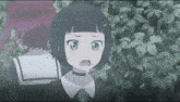 a little girl with a choker around her neck is standing in front of a bush