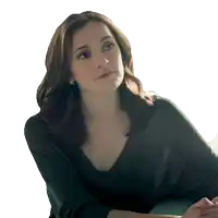 a woman in a black shirt looks to the side with her eyes closed