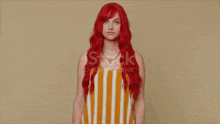 a woman with red hair is flexing her muscles on a beige background