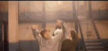 a man is standing in a room with his arms outstretched .