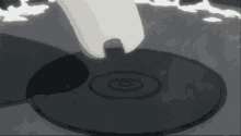 a person 's foot is standing on a black object with a circle on it
