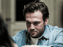 a man with a beard wearing a blue shirt
