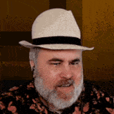 a man with a beard is wearing a hat and ear buds