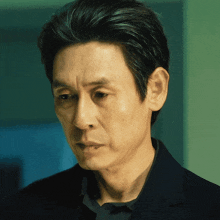 a close up of a man 's face with a black shirt on