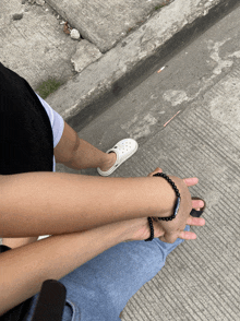 a person wearing a bracelet that says ' jesus ' on it holds another person 's hand