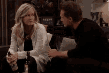 a man and a woman are looking at each other while sitting next to each other .