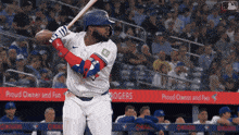 a blue jays baseball player swings his bat at the ball