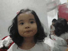 a little girl with a pink flower in her hair