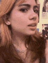 a close up of a woman 's face with a necklace on .