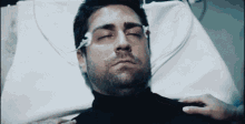 a man is laying in a hospital bed with a needle in his nose