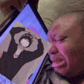 a person crying with a picture of a man wearing a mask and a shirt that says roi