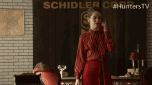 a woman is talking on a phone in front of a sign that says schilder corp