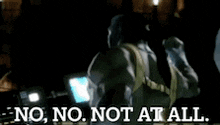 a man is standing in a dark room with the words `` no , no , not at all '' written on the bottom .
