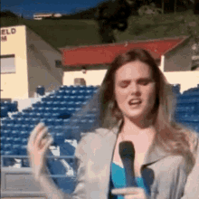 a woman is talking into a microphone in front of a building that says eld on it