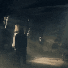 a person standing in a dark room with graffiti on the wall that says ' a.m. ' on it