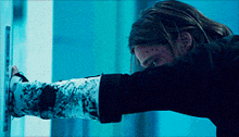 a man in a black shirt is reaching for something in a dark room