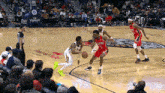 a basketball game is being played in front of a crowd with a tissot banner in the background