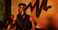 a man wearing sunglasses is singing into a microphone in front of a wall with the letter m on it