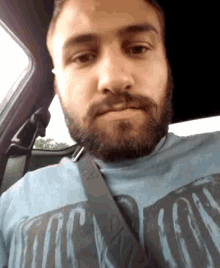 a man with a beard is wearing a blue shirt that says tor