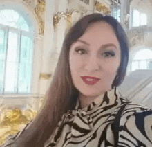 a woman with long hair is taking a selfie in a zebra print shirt .