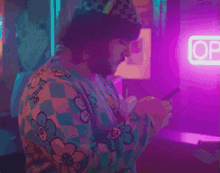 a blurred image of a person standing in front of a neon sign that says noodles