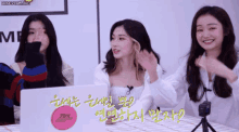 three women are sitting in front of a laptop with a pink sticker that says fire dance