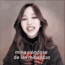 a woman is smiling with the words mina riendose de las minaistas written below her