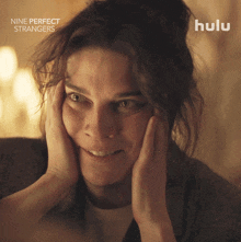 a close up of a woman 's face with nine perfect strangers written on the bottom