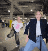 a boy and a girl are dancing together in a parking garage