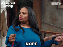 a woman holding a mop with the word nope written on it