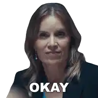 a woman in a suit says okay in front of her face