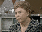 an older woman wearing a polka dot shirt and earrings