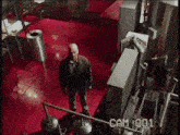 a man is standing in a room with cam 001 written on the bottom
