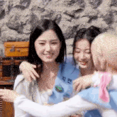a group of young women are hugging each other and smiling .