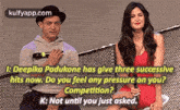 a man and a woman are sitting next to each other and the woman is asking the man if he has three successful hits now .