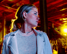 a woman wearing a white jacket and a gray shirt