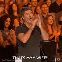 a man is applauding in front of a crowd and says that 's my wife !