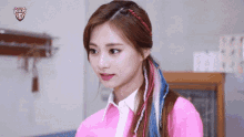a close up of a woman wearing a pink shirt and white shirt