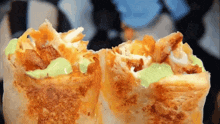 a close up of a burrito with a green sauce on top
