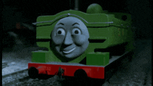 a green and gray train with the word thomas on the front of it