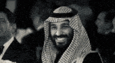 a man in a keffiyeh is smiling in a black and white photo with the letters lgo on the bottom