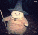 a cat is wearing a witch hat and holding a cane