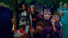 a woman in a maleficent costume looks at herself in the mirror